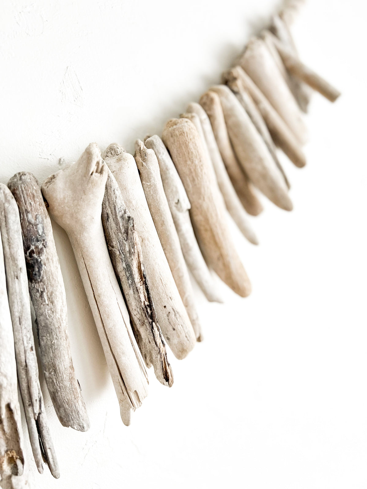 This whitewashed driftwood hanging showcases simplistic beauty with natural textures & details that can only be found in nature. Adding an element of coastal & rustic charm, this piece is sure to make a beautiful focal point in your space.