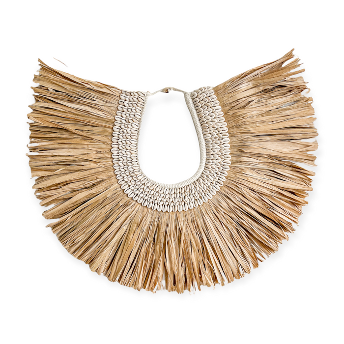 Hand crafted with multiple rows of cowrie shells sewn onto a thick crochet backing with a natural raffia fringe surround. This horseshoe shaped beauty can be hung directly on a wall or from your favourite entrance hook or hanger. Raffia tribal necklace wall hangings for your tropical villa styled interior 
