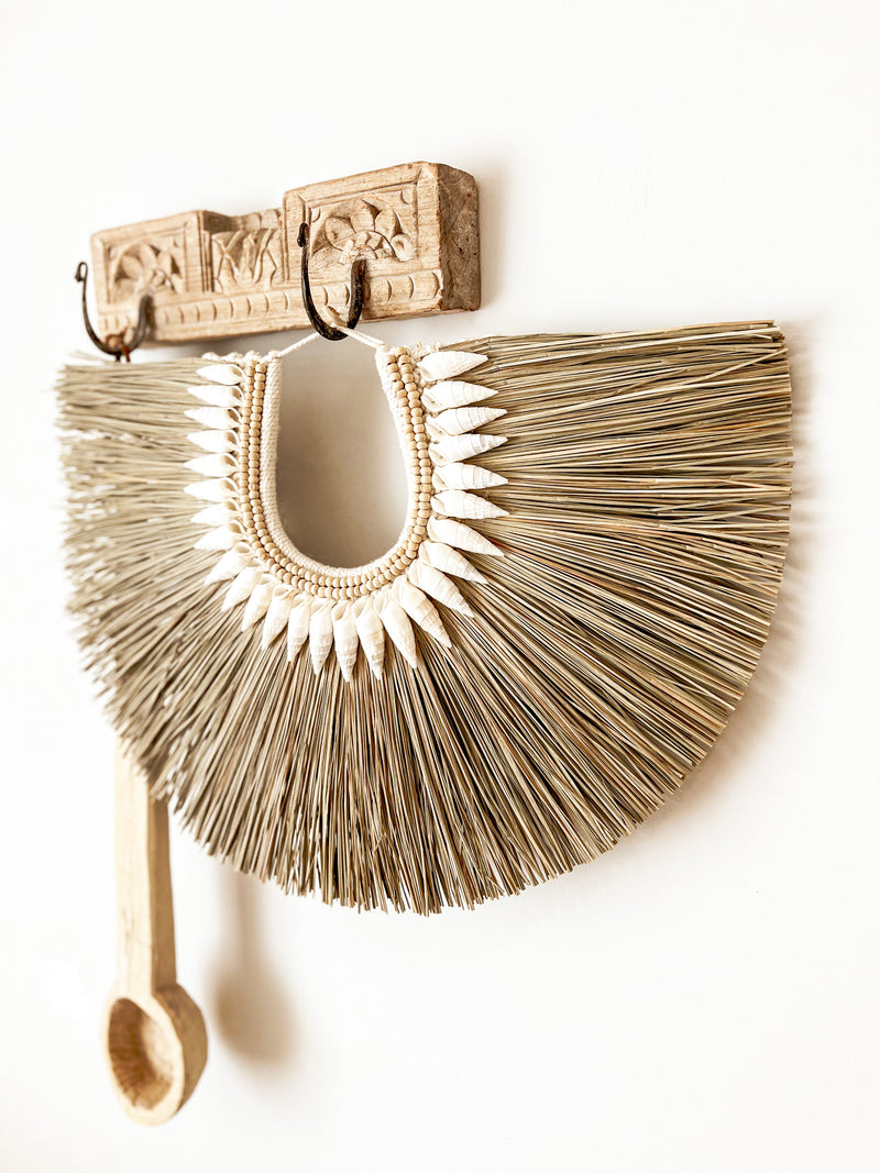 An eye catching mix of natural elements intended to inject a coastal vibe to any interior. The Mali seagrass hanging hosts raw texture and is intricately detailed with timber beads & natural seashells hand sewn to a thick crochet backing.  Simply hang on a wall or your favourite entrance hook to create a welcoming coastal statement to your space.  