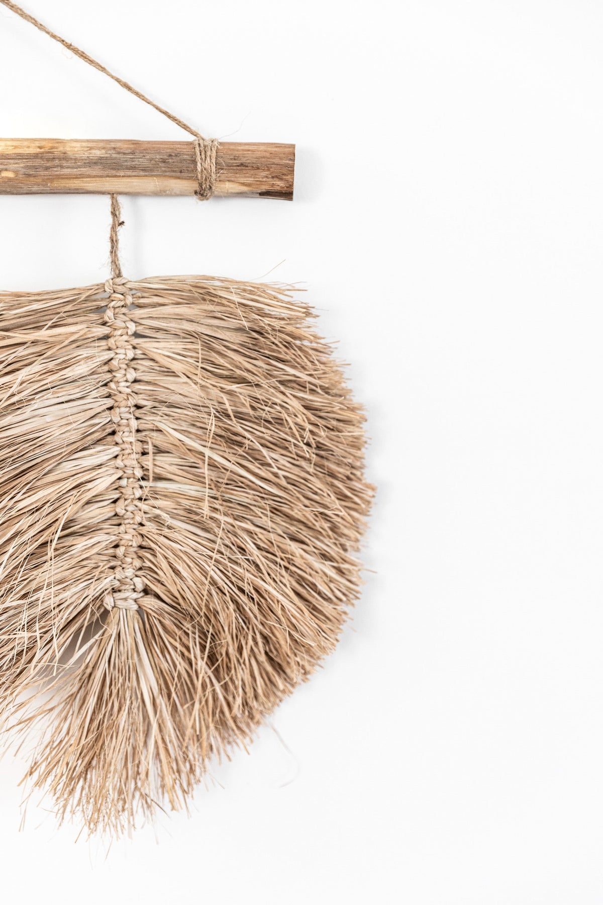 A trio of hand braided raffia leaves hang from a natural driftwood piece found by the coast & completed with a Jute hanger. This wall hanging is ideal for those who love raw texture & the feel of natural materials in their home.