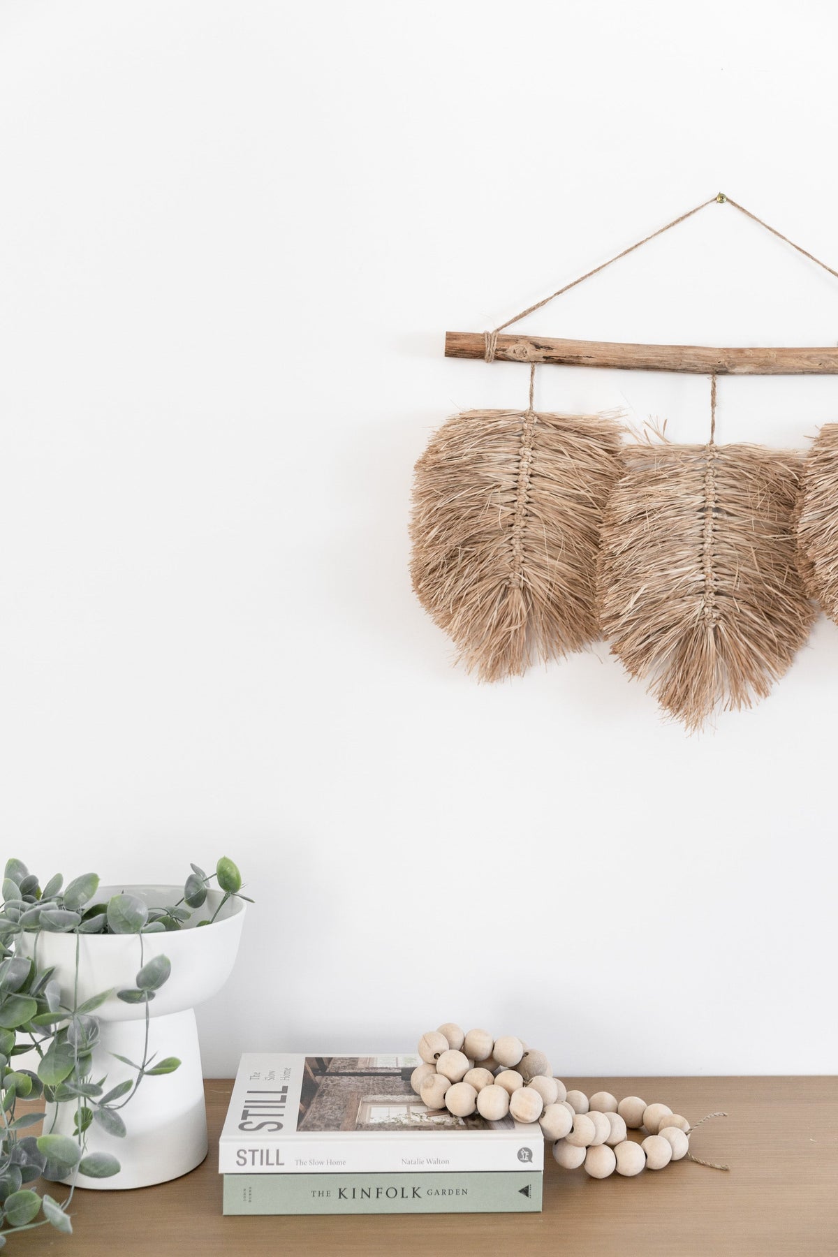 A trio of hand braided raffia leaves hang from a natural driftwood piece found by the coast & completed with a Jute hanger. This wall hanging is ideal for those who love raw texture & the feel of natural materials in their home. Rustic interior home decor