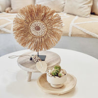 A centrepiece of curated feature shells surrounded by fringing of dried raffia creates this gorgeous table top decor piece.  The Lexi design has been inspired by our raffia juju wall hangings, only this one sits complete on a custom made stand.  Ideal for display on a console, side table, shelf or a picture ledge to level up your styling & keep a consistent flow throughout your home.