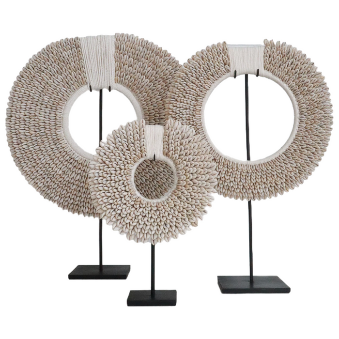 The Authentic Papua Necklace features hundreds of perfectly placed cowrie shells intricately hand sewn onto a thick crochet backing. Cowrie shell necklace on stand or wall hanging. Coastal decor